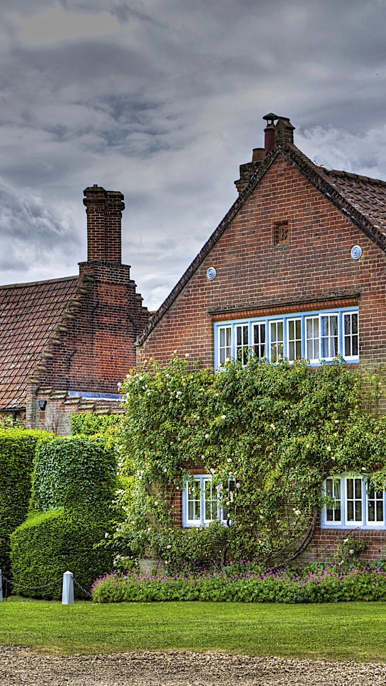 Brown Brick House With Green Grass Lawn and Trees Under Gray Clouds. Wallpaper in 750x1334 Resolution