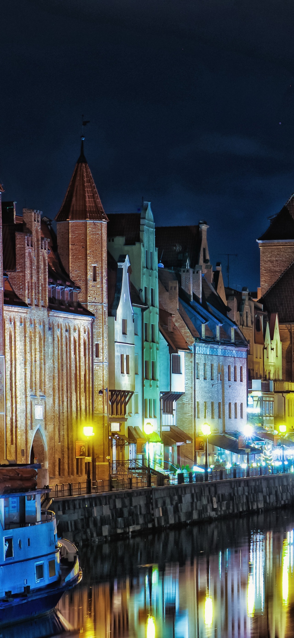 Bâtiment en Béton Brun Près D'un Plan D'eau Pendant la Nuit. Wallpaper in 1125x2436 Resolution