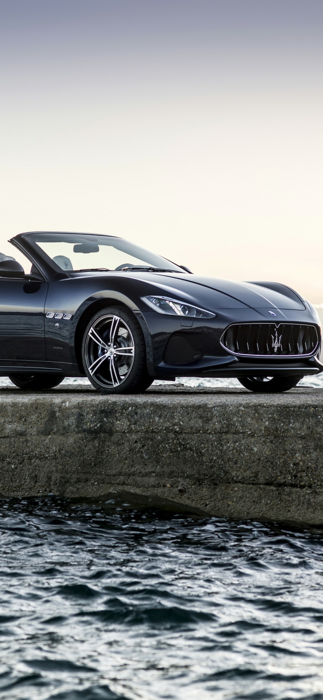 Black Coupe on Gray Concrete Road During Daytime. Wallpaper in 1125x2436 Resolution