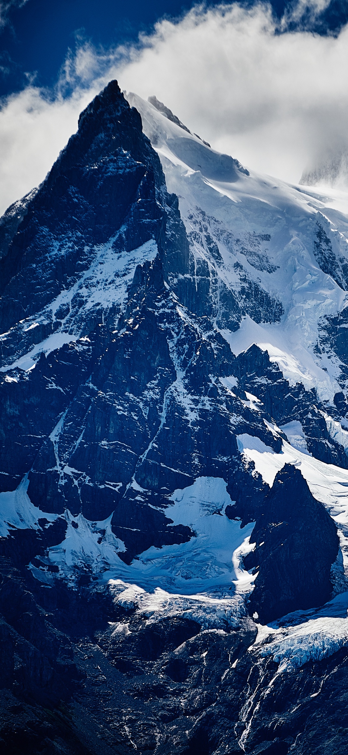 Montaña Cubierta de Nieve Bajo el Cielo Nublado Durante el Día. Wallpaper in 1125x2436 Resolution