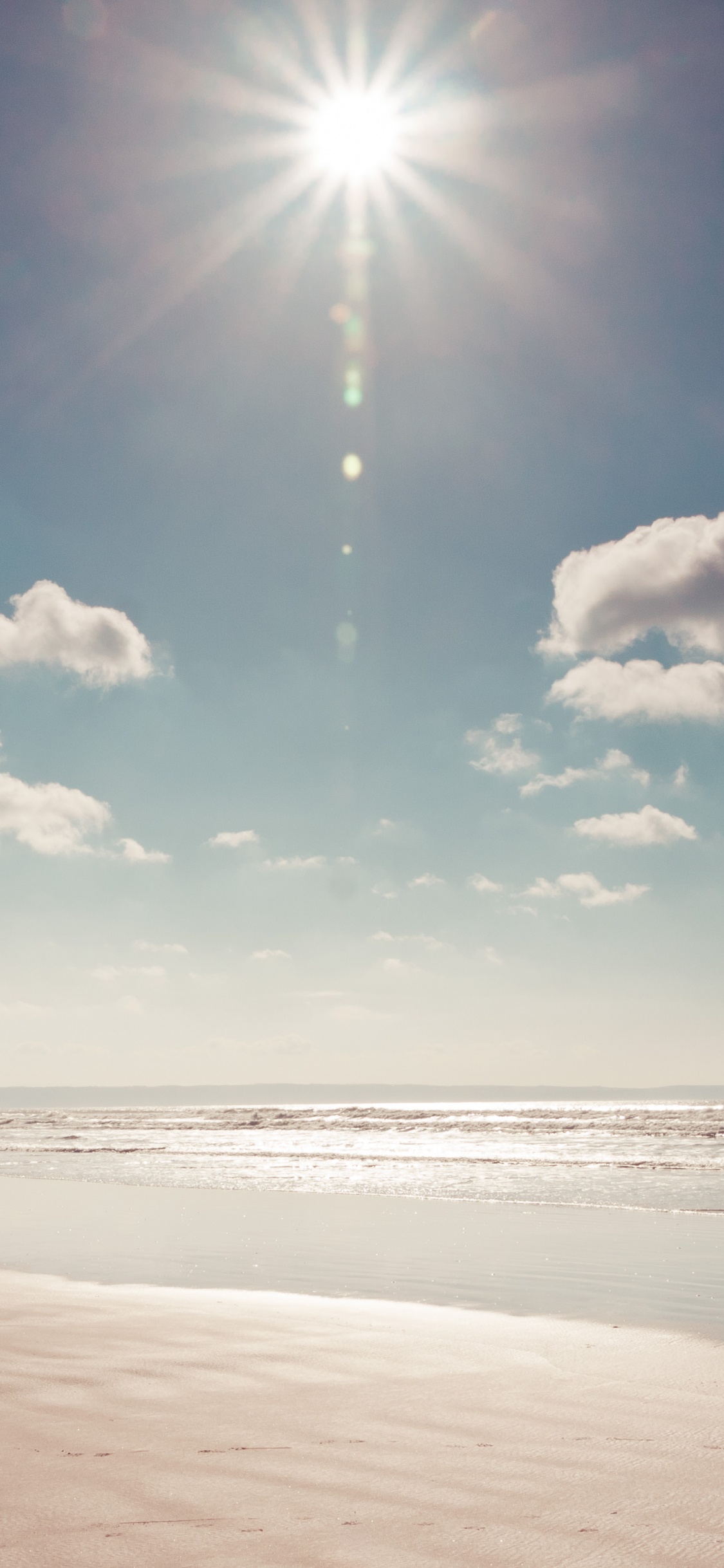 White Clouds and Blue Sky Over The Sea. Wallpaper in 1125x2436 Resolution