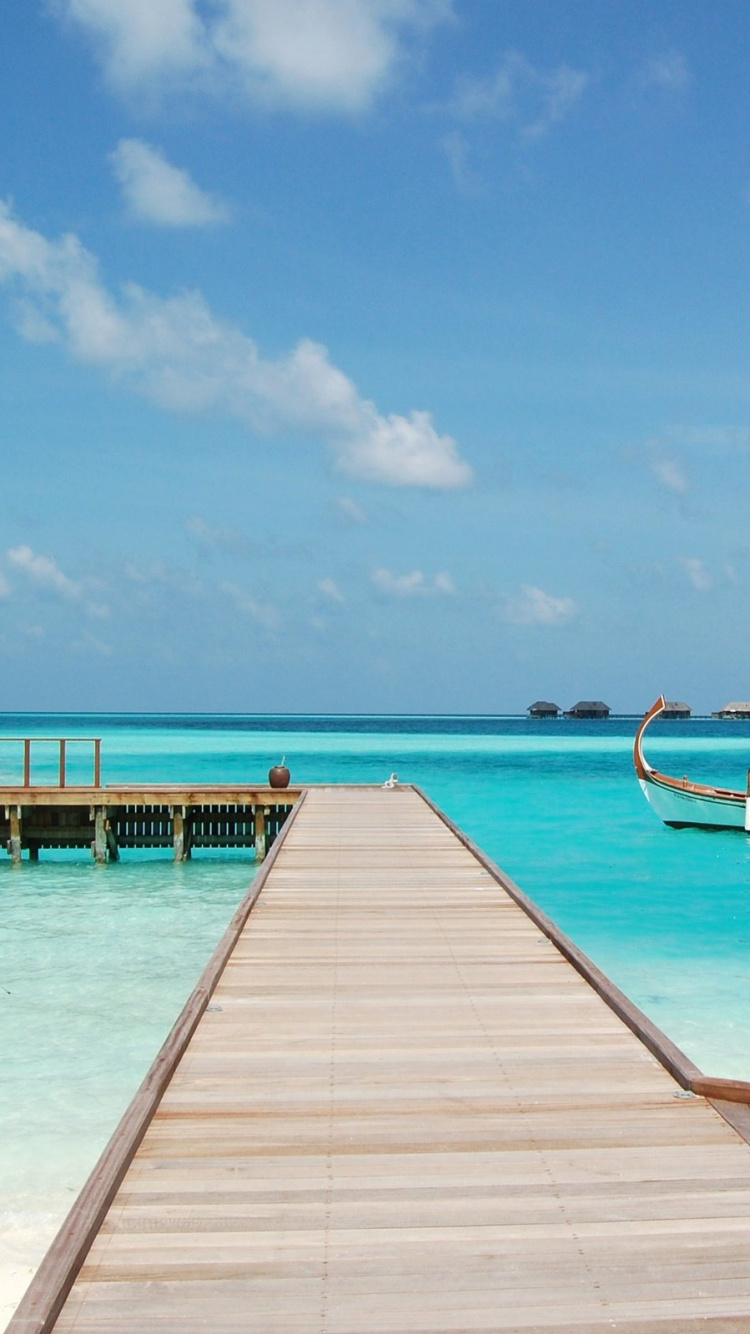 Brown Wooden Dock on Blue Sea Under Blue Sky and White Clouds During Daytime. Wallpaper in 750x1334 Resolution