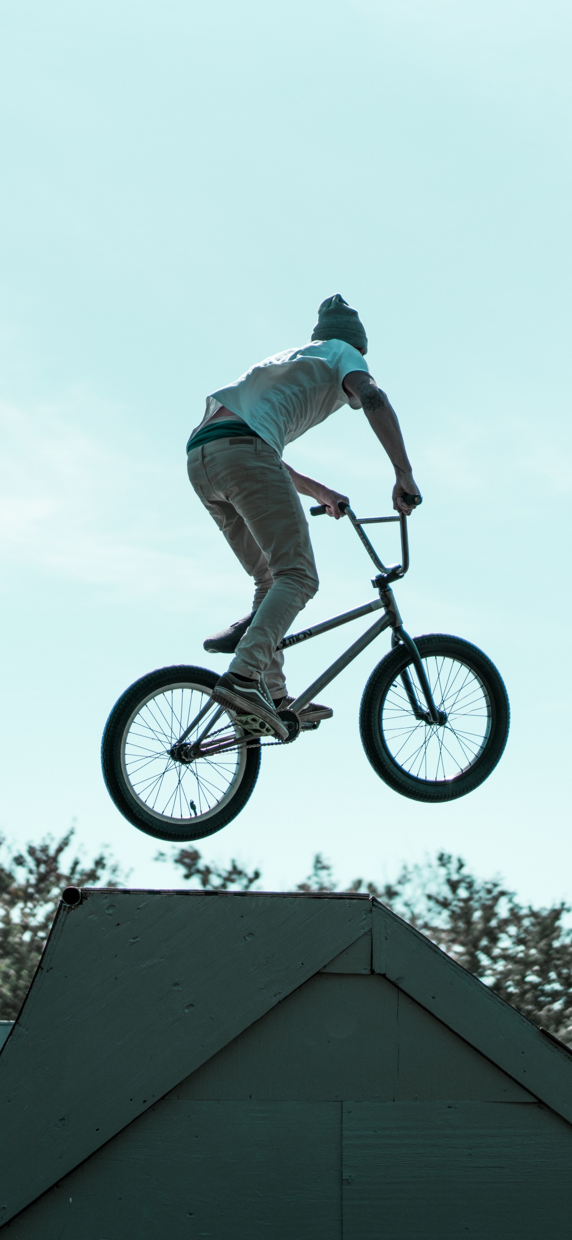 Hombre en Camisa Blanca Montando en Bicicleta. Wallpaper in 1125x2436 Resolution