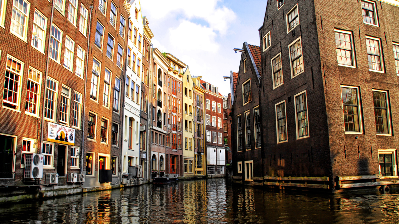 Braunes Betongebäude Neben Dem Fluss Unter Blauem Himmel Tagsüber. Wallpaper in 1280x720 Resolution