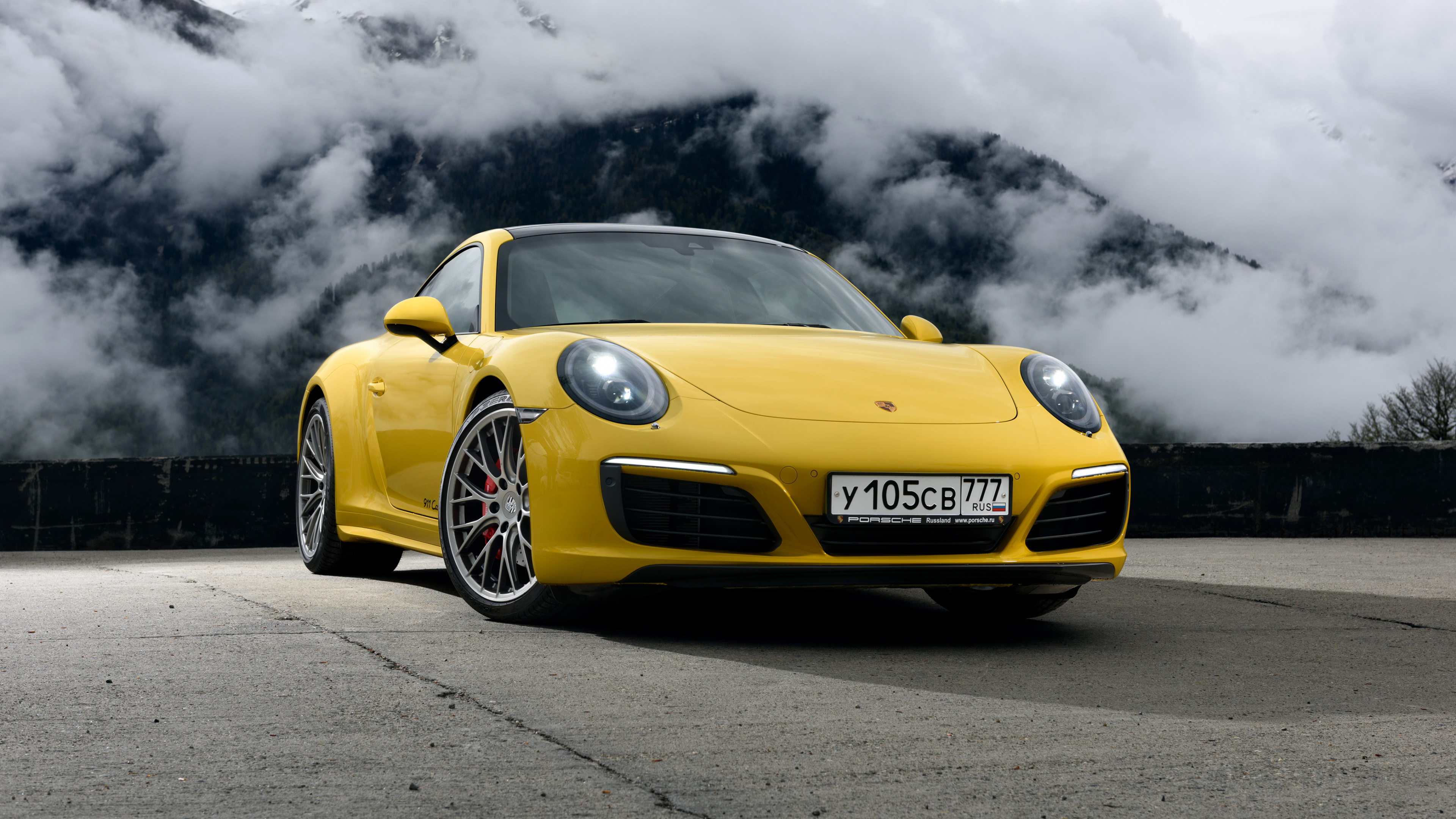 Porsche 911 Amarillo Sobre Carretera de Asfalto Negro Bajo Nubes Grises. Wallpaper in 3840x2160 Resolution