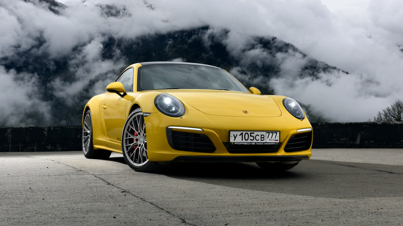 Yellow Porsche 911 on Black Asphalt Road Under Gray Clouds. Wallpaper in 1366x768 Resolution