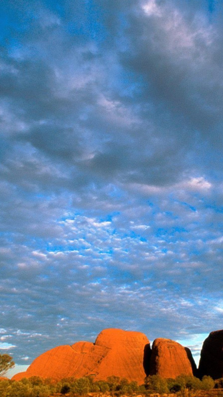 Montaña Rocosa Marrón Bajo un Cielo Azul y Nubes Blancas Durante el Día. Wallpaper in 750x1334 Resolution