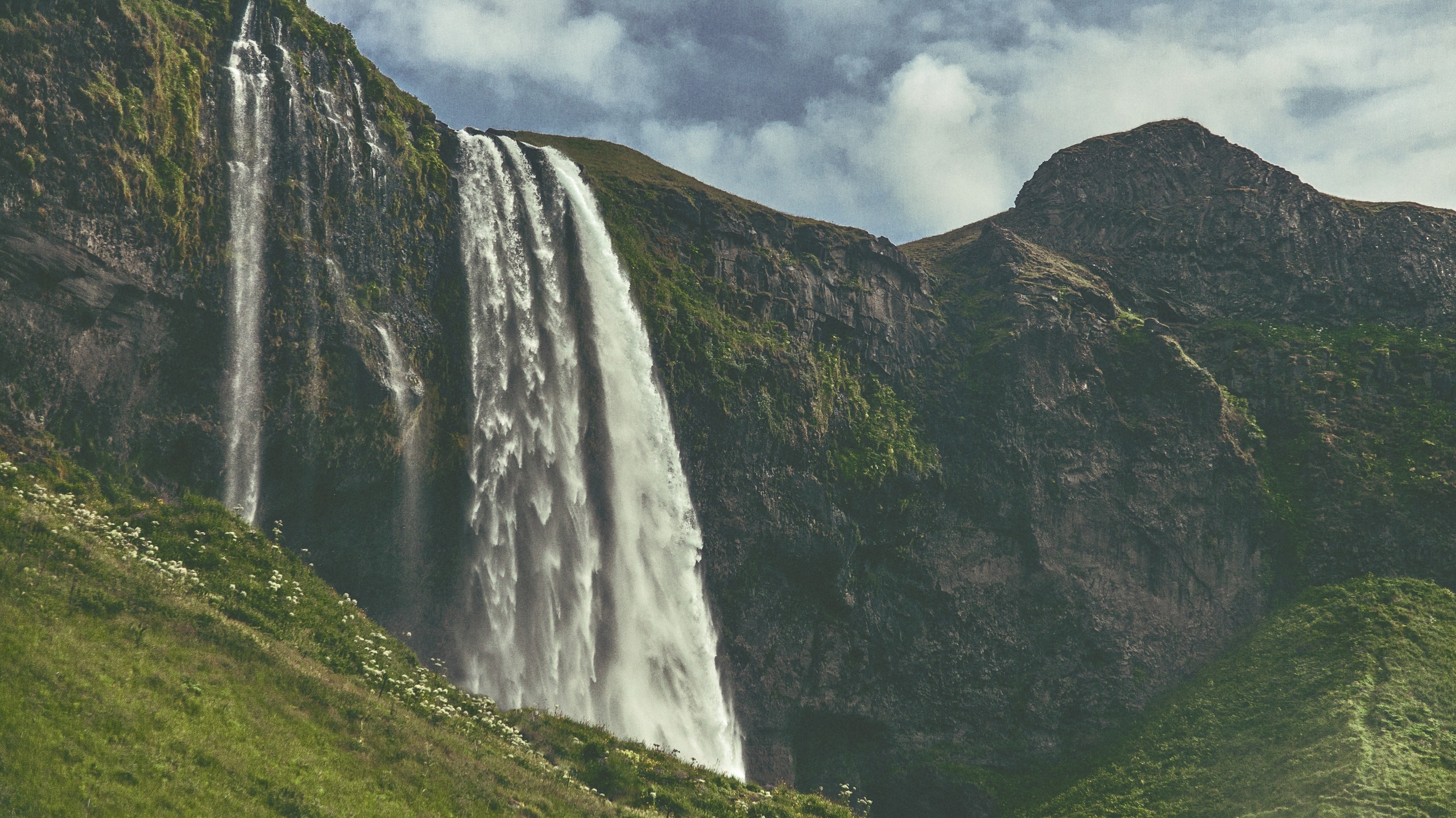 Cascadas en el Campo de Hierba Verde Bajo un Cielo Nublado Durante el Día. Wallpaper in 2560x1440 Resolution