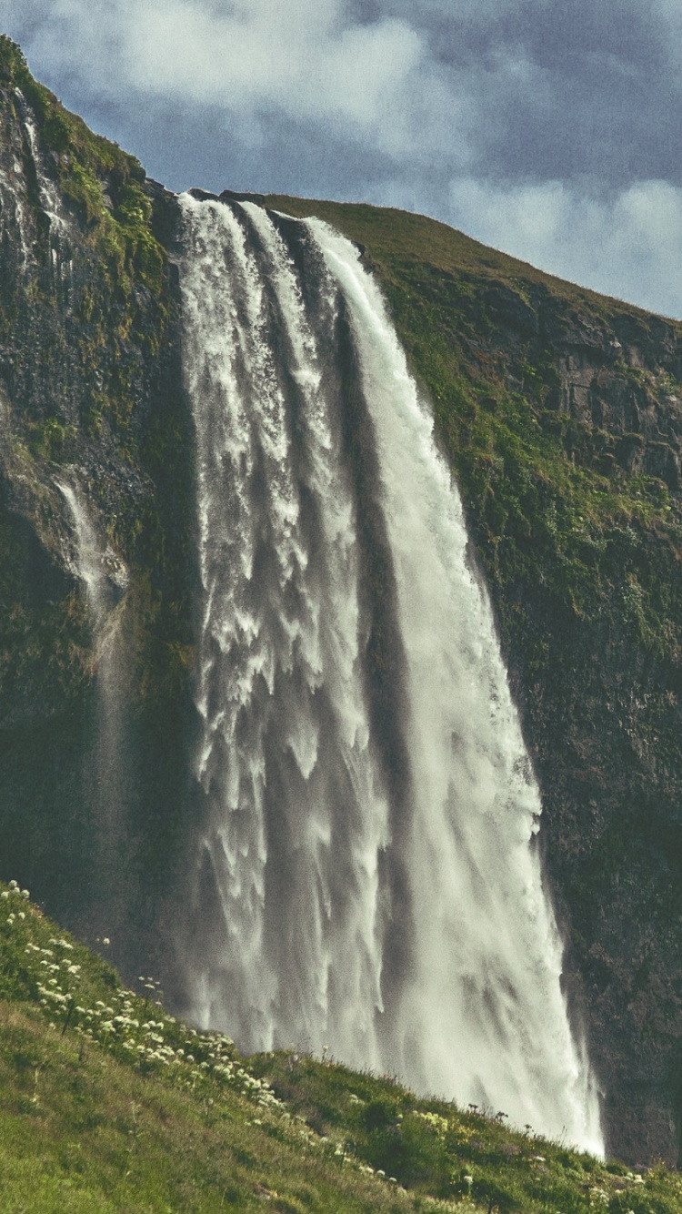 Wasserfälle Auf Grüner Wiese Unter Bewölktem Himmel Tagsüber. Wallpaper in 750x1334 Resolution