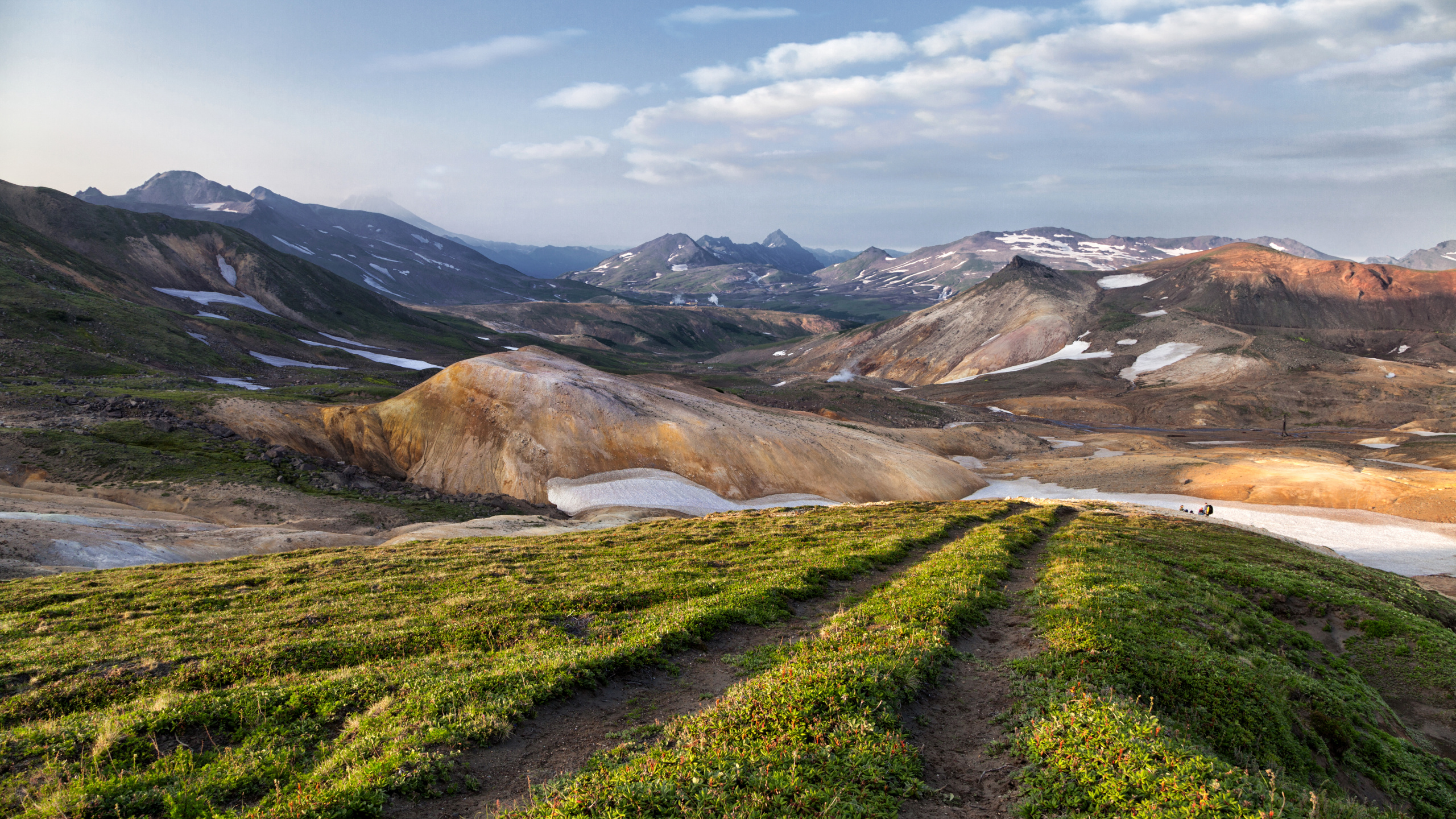 Green Grass Field Near Brown Mountain Under White Clouds During Daytime. Wallpaper in 2560x1440 Resolution