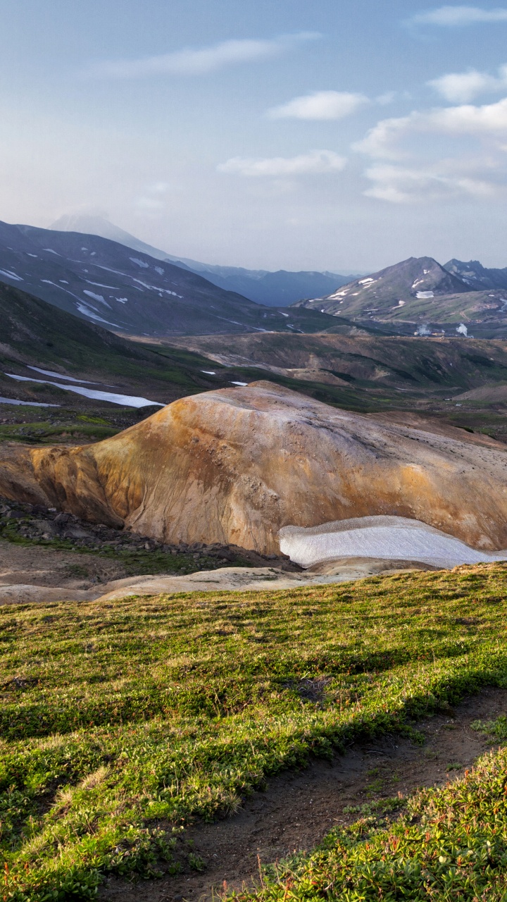 Green Grass Field Near Brown Mountain Under White Clouds During Daytime. Wallpaper in 720x1280 Resolution