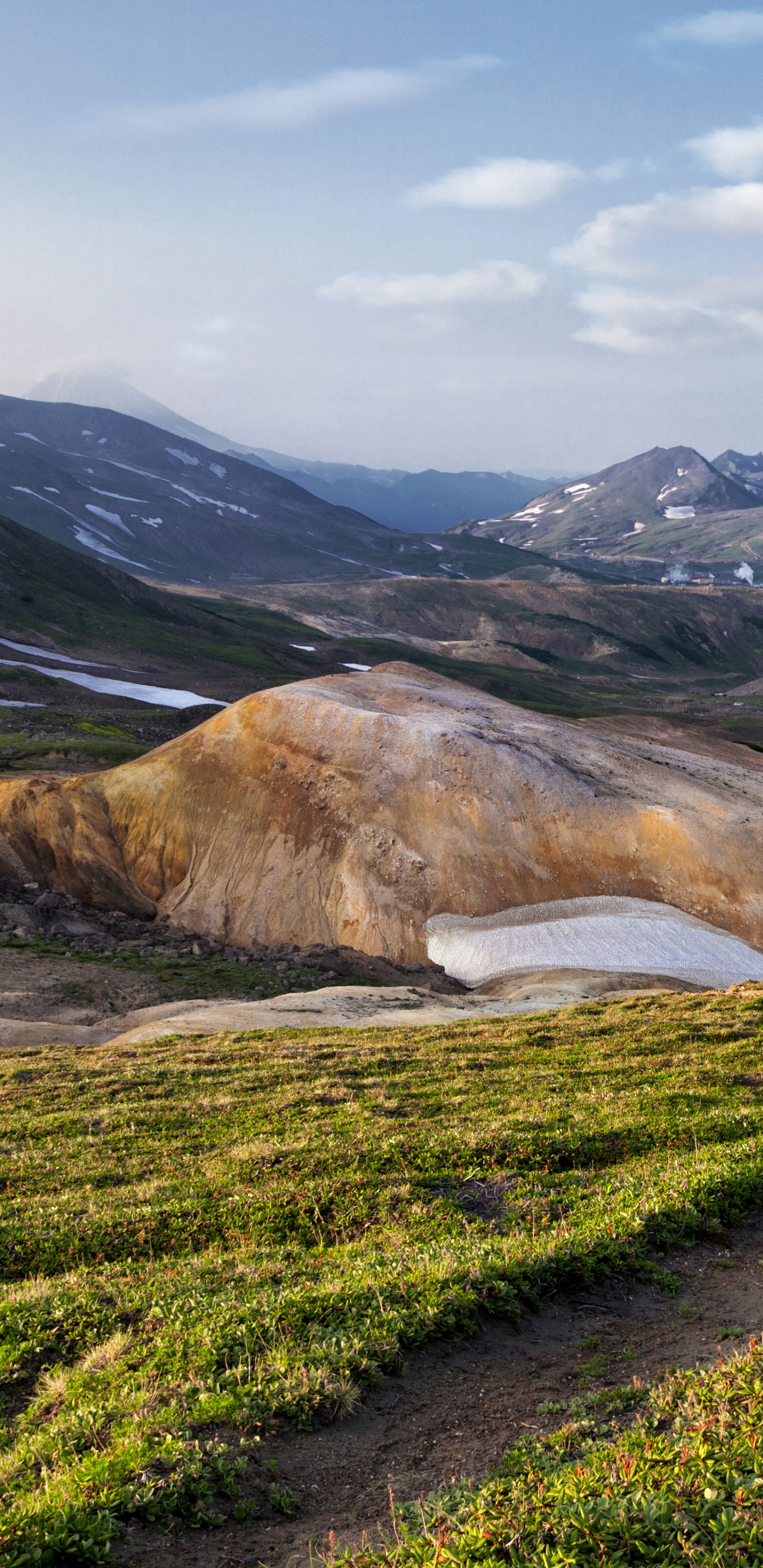 Grünes Grasfeld in Der Nähe Des Braunen Berges Unter Weißen Wolken Tagsüber. Wallpaper in 1440x2960 Resolution