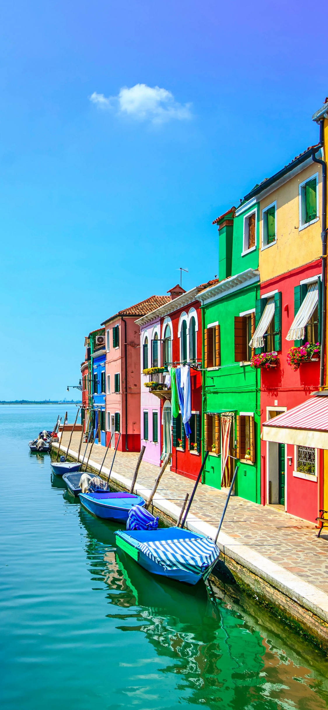 Blue and White Boat on River Near Houses During Daytime. Wallpaper in 1125x2436 Resolution