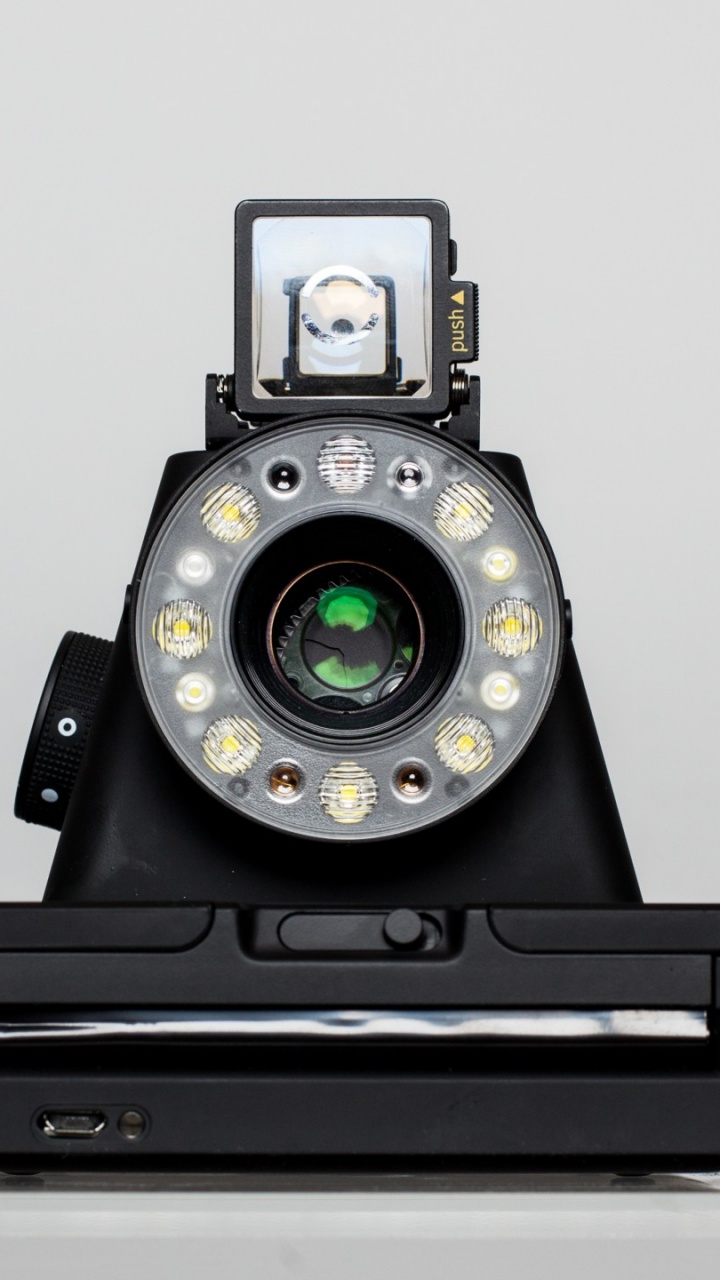 Schwarze Und Silberne Kamera Auf Weißem Tisch. Wallpaper in 720x1280 Resolution