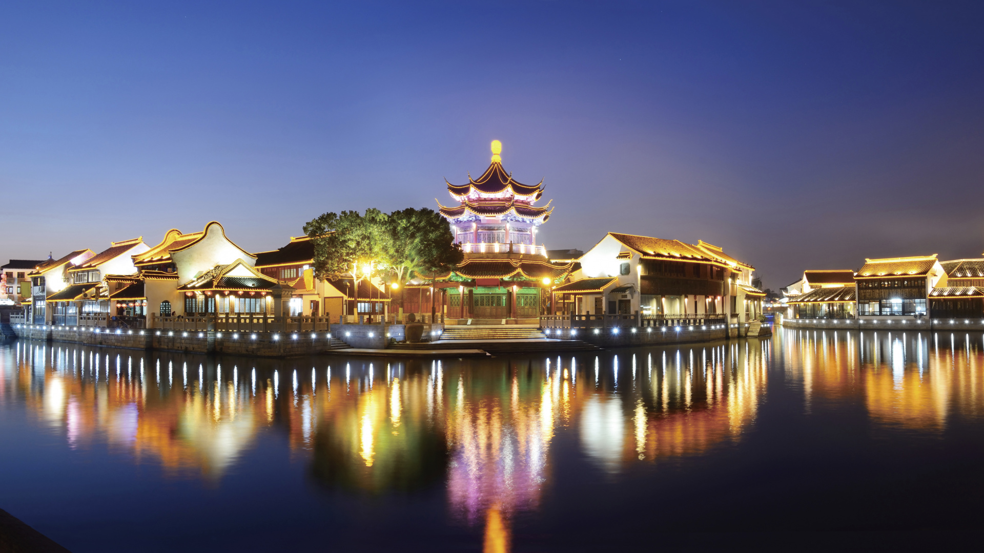Brown and White Temple Near Body of Water During Night Time. Wallpaper in 1920x1080 Resolution
