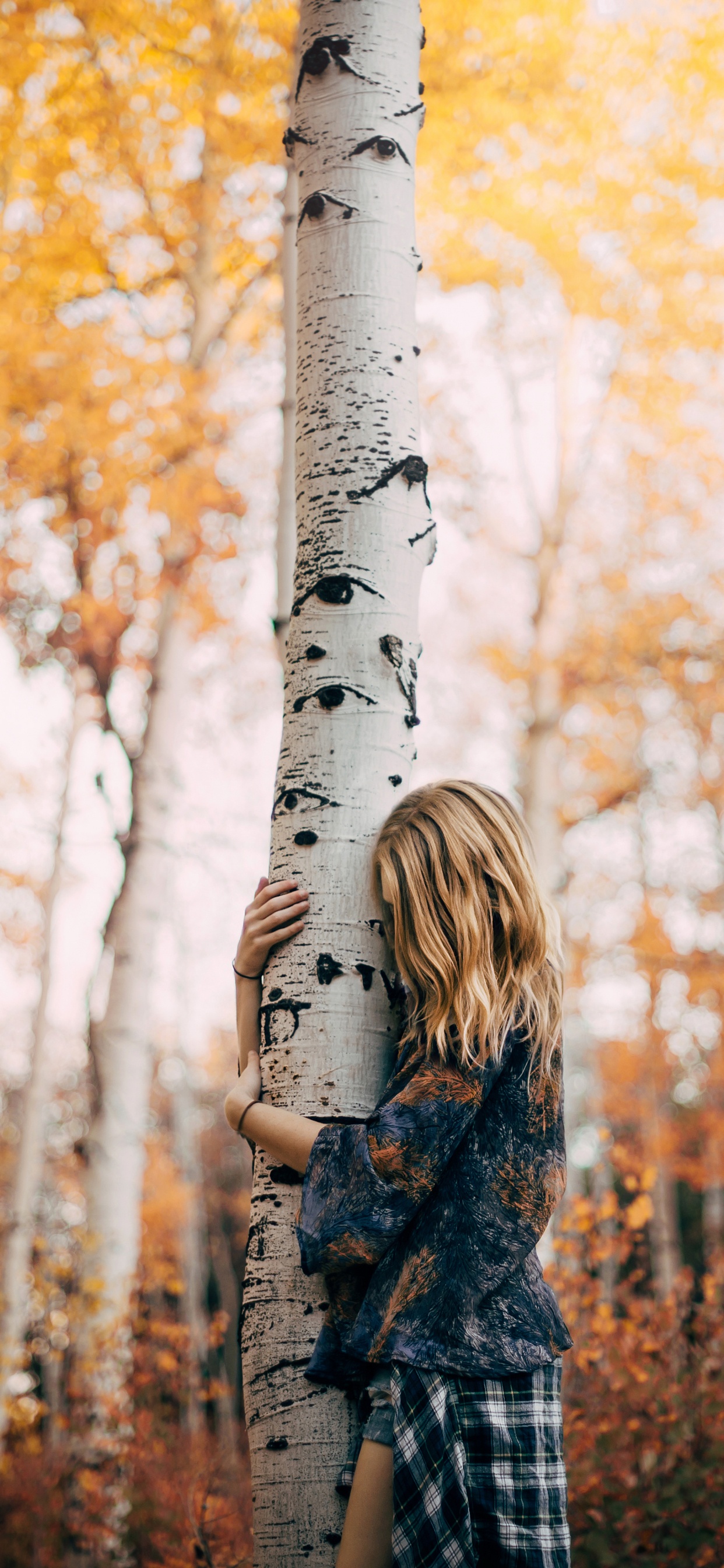 Femme en Manteau à Carreaux Noir et Blanc Debout Près D'un Arbre Blanc Pendant la Journée. Wallpaper in 1242x2688 Resolution