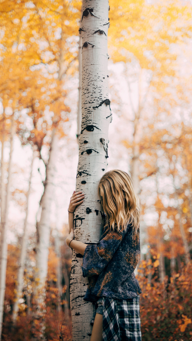 Femme en Manteau à Carreaux Noir et Blanc Debout Près D'un Arbre Blanc Pendant la Journée. Wallpaper in 750x1334 Resolution