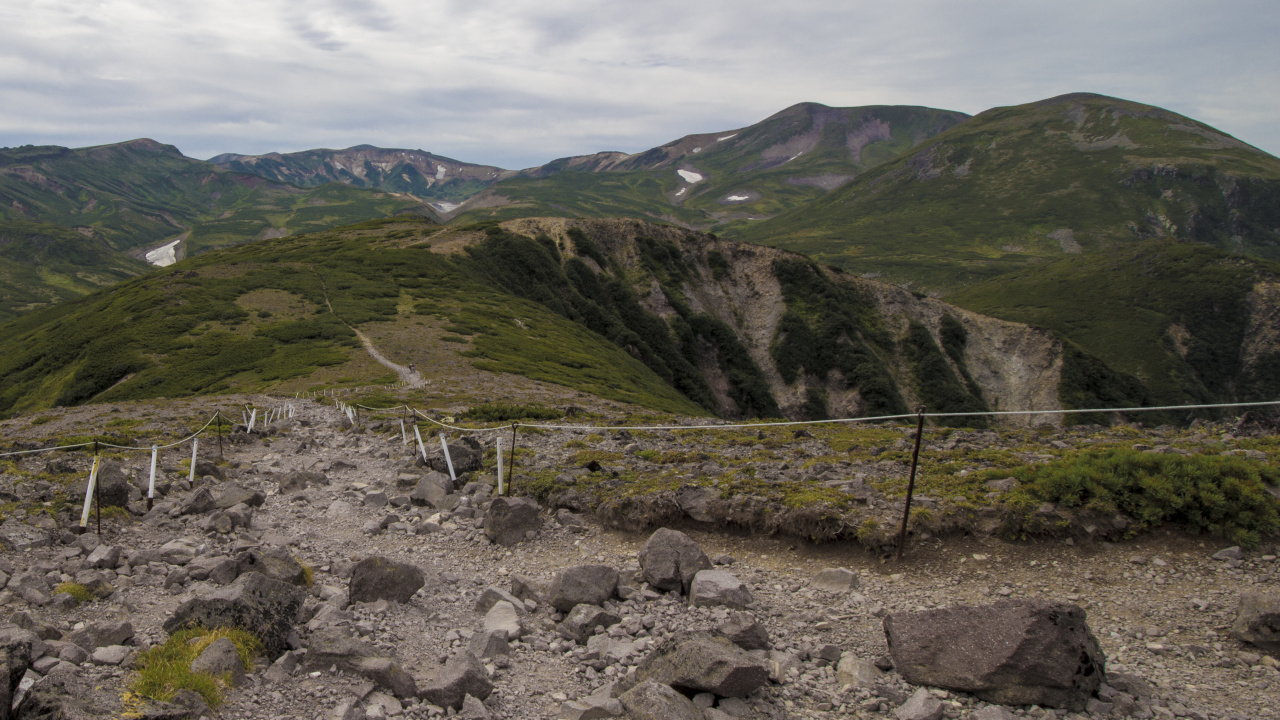 Campo de Hierba Verde Cerca de la Montaña Bajo Nubes Blancas Durante el Día. Wallpaper in 1280x720 Resolution