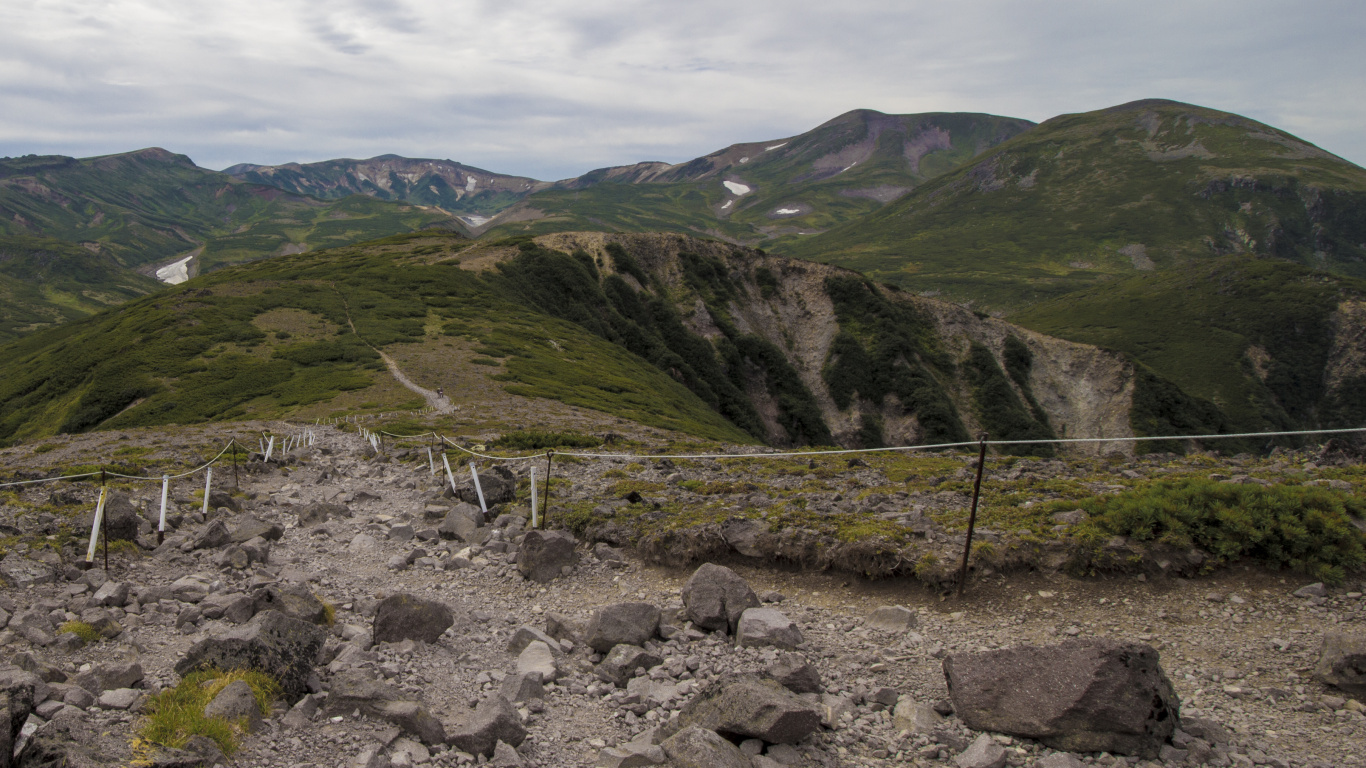 Green Grass Field Near Mountain Under White Clouds During Daytime. Wallpaper in 1366x768 Resolution