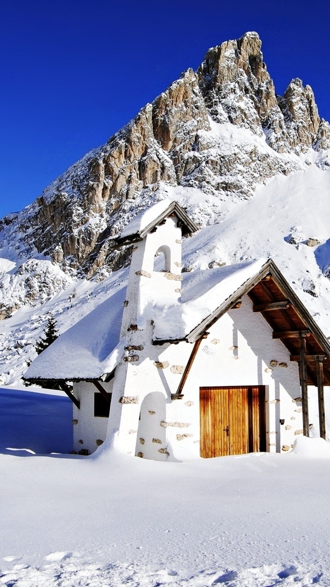 Braunes Holzhaus Auf Schneebedecktem Boden in Der Nähe Von Schneebedeckten Bergen Tagsüber During. Wallpaper in 1080x1920 Resolution