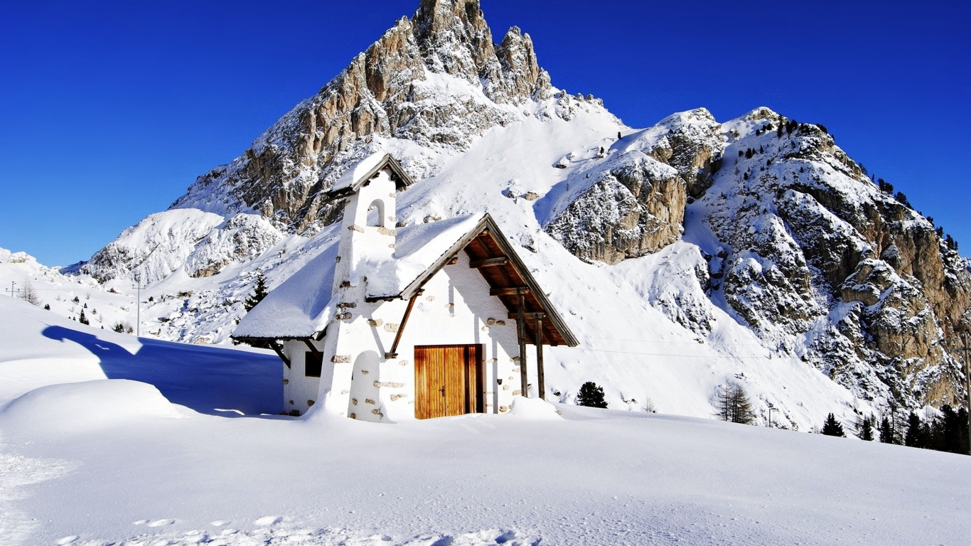 Braunes Holzhaus Auf Schneebedecktem Boden in Der Nähe Von Schneebedeckten Bergen Tagsüber During. Wallpaper in 1366x768 Resolution