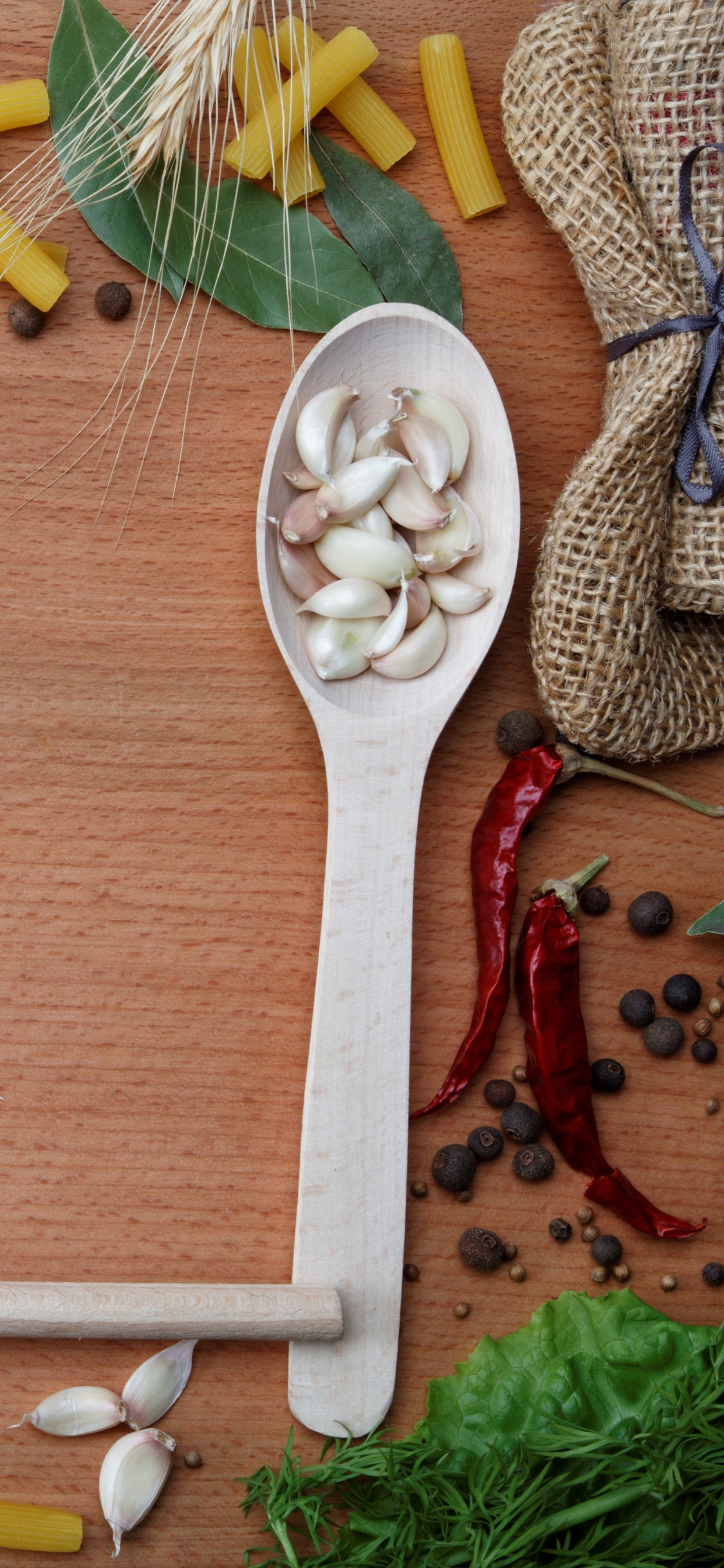 Brown Wooden Spoon With Assorted Spices. Wallpaper in 1125x2436 Resolution