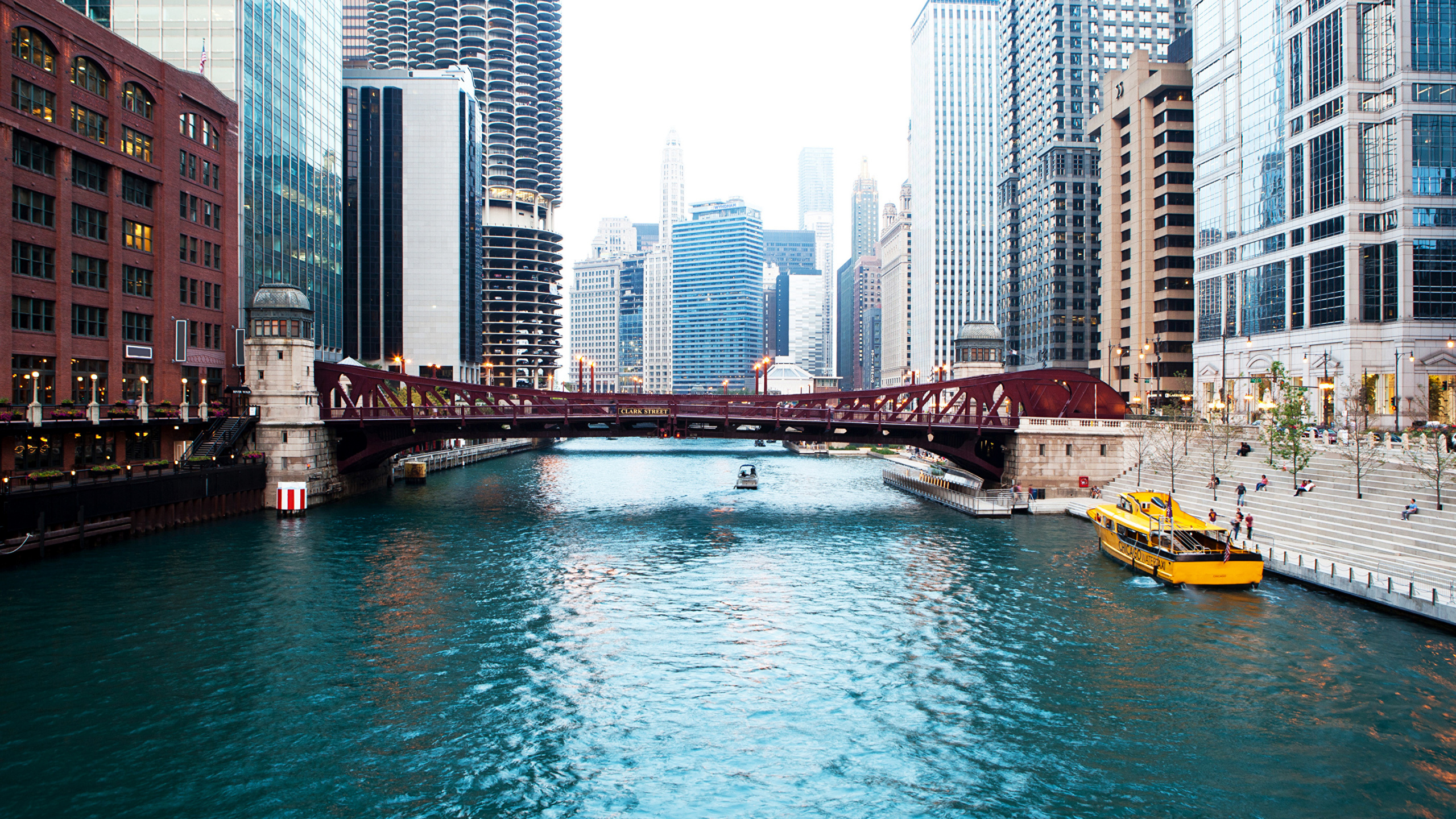 Bateau Blanc et Noir Sur la Rivière Près Des Bâtiments de la Ville Pendant la Journée. Wallpaper in 2560x1440 Resolution