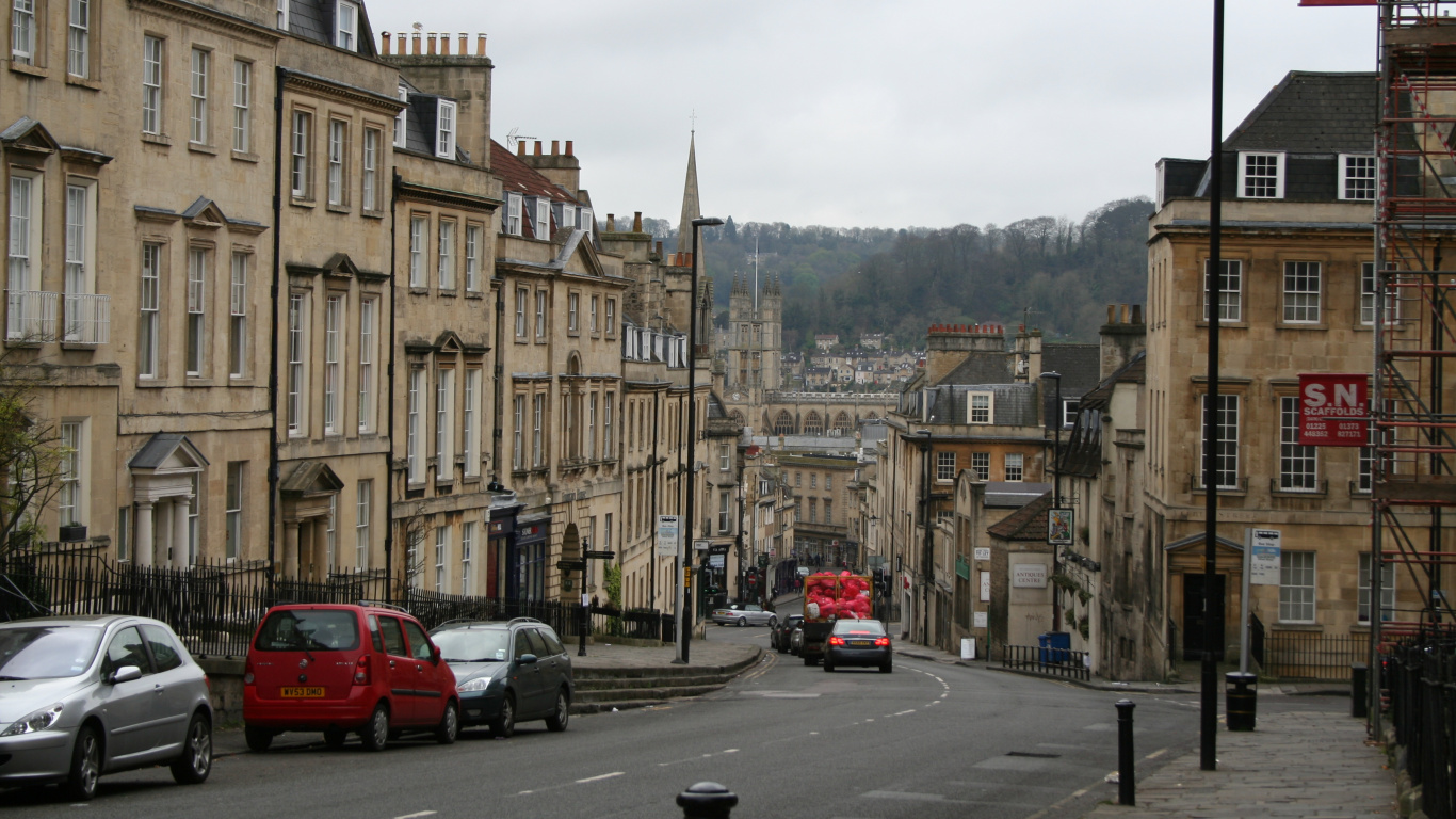 Rotes Auto Auf Der Straße in Der Nähe Von Braunem Betongebäude Tagsüber During. Wallpaper in 1366x768 Resolution