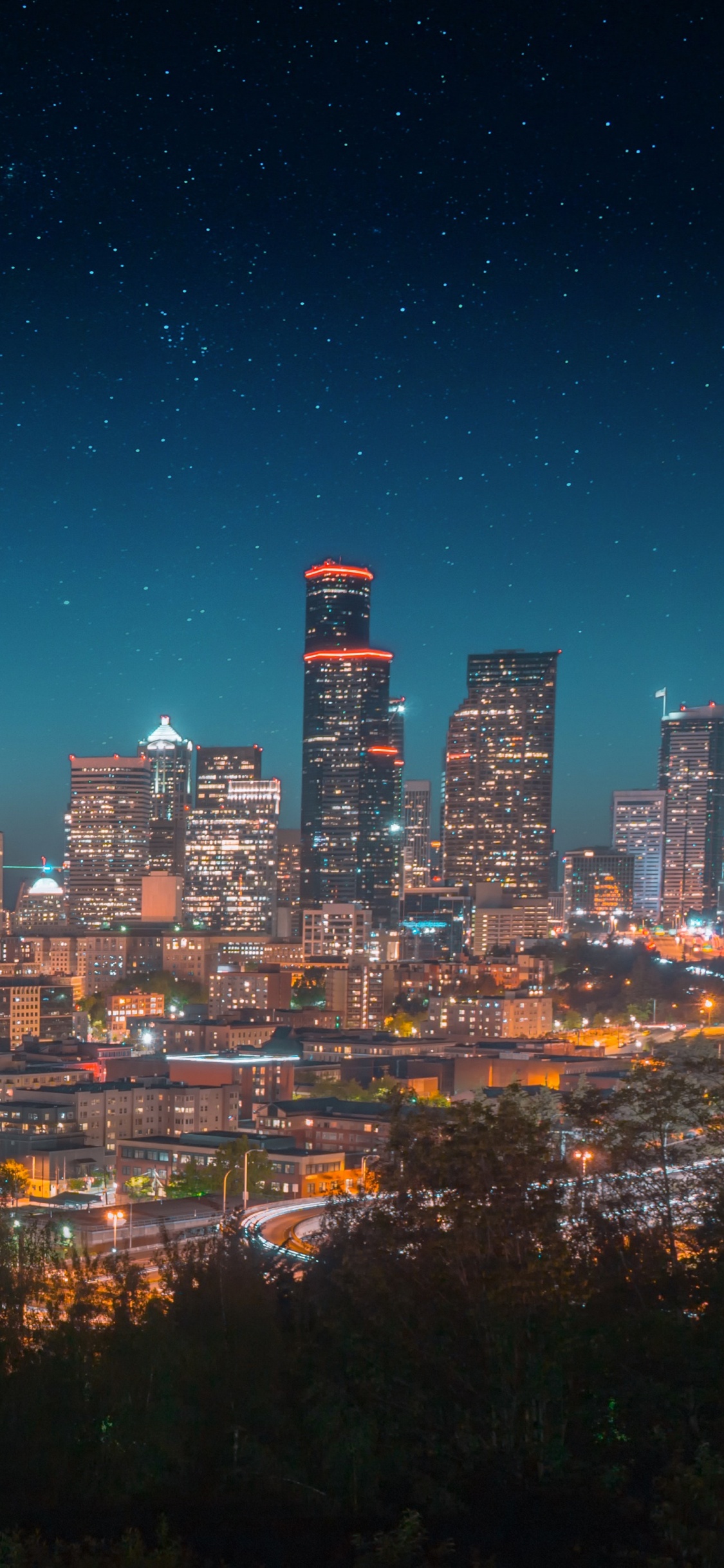 Ville Avec Des Immeubles de Grande Hauteur Pendant la Nuit. Wallpaper in 1125x2436 Resolution