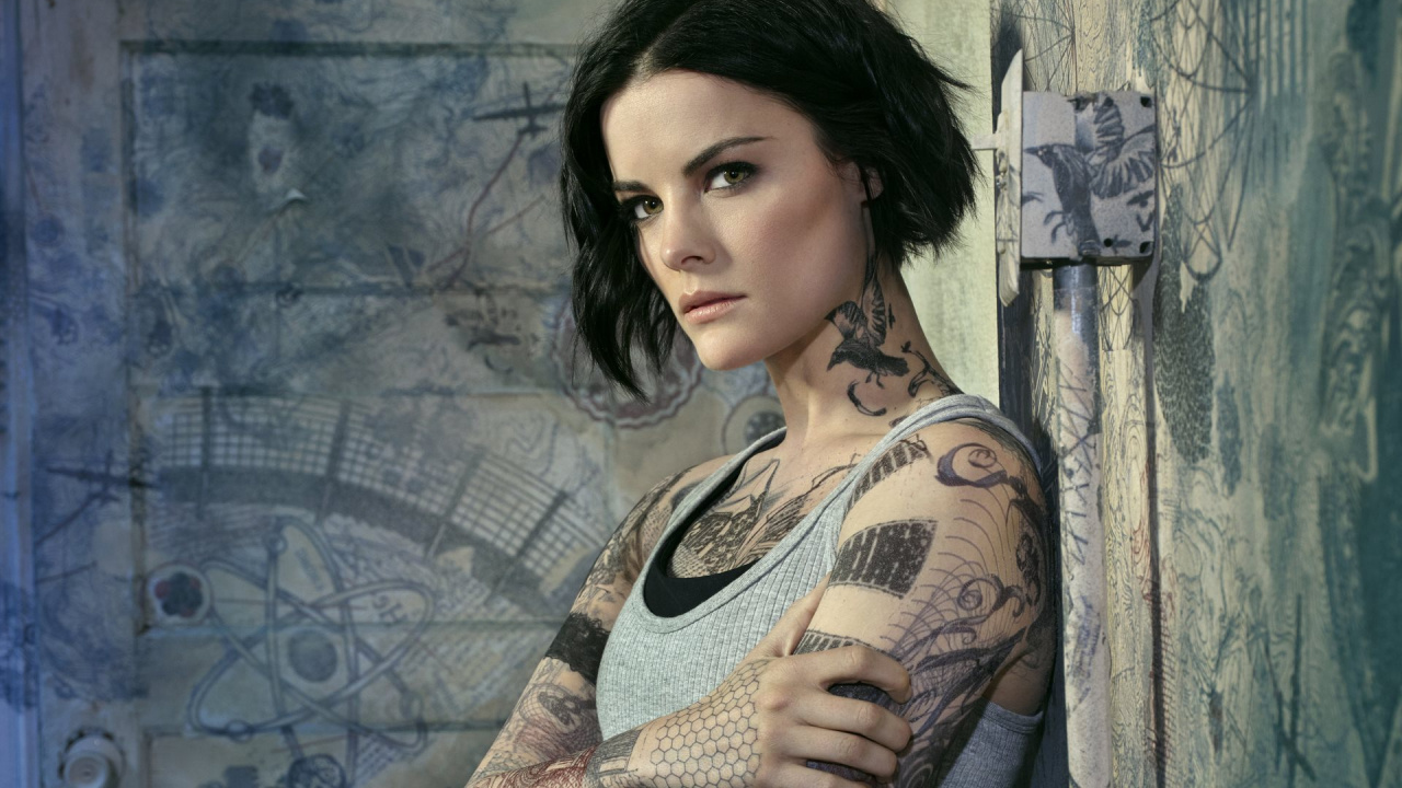Frau in Grauer Strickjacke Mit Schwarzem Blumen Tattoo an Der Schulter. Wallpaper in 1280x720 Resolution