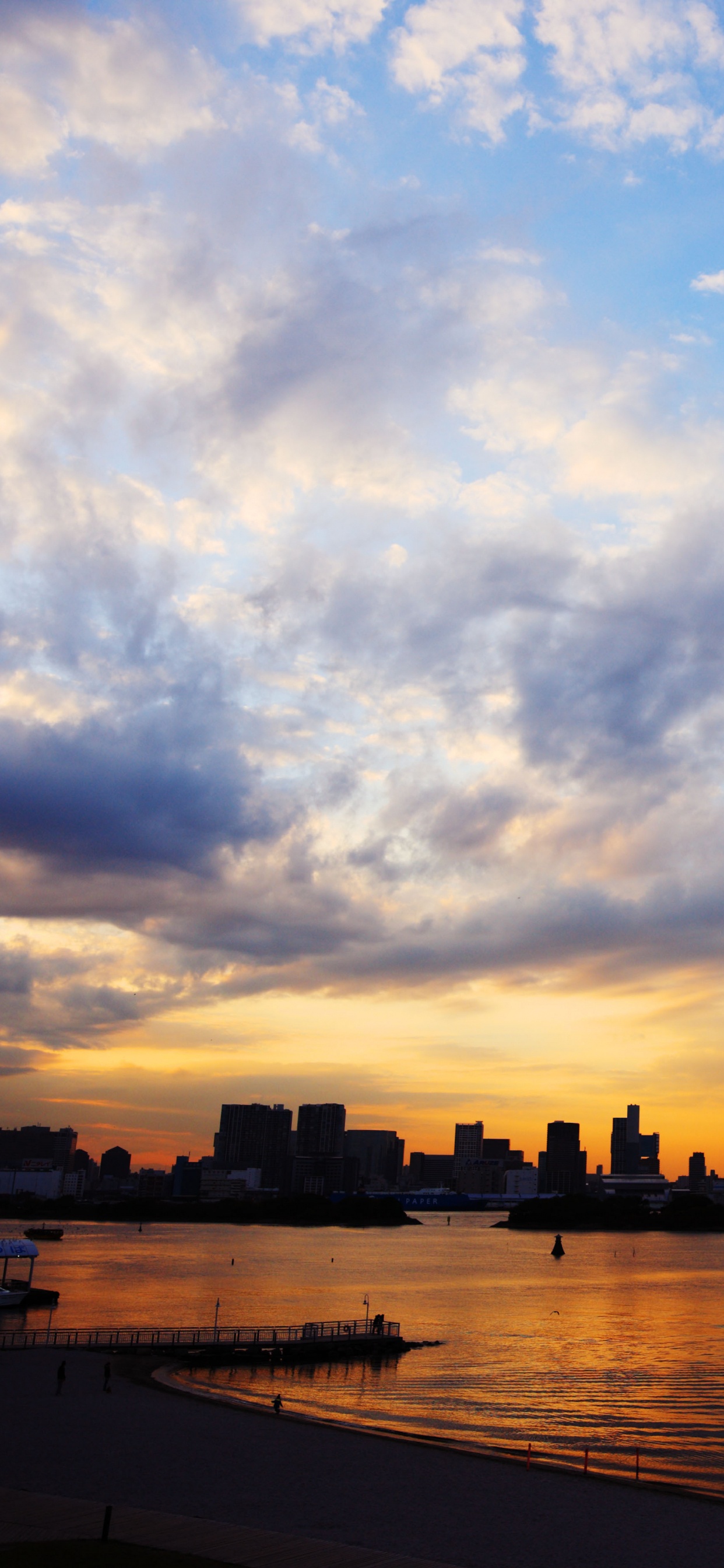 Silhouette of City Buildings Near Body of Water During Sunset. Wallpaper in 1242x2688 Resolution