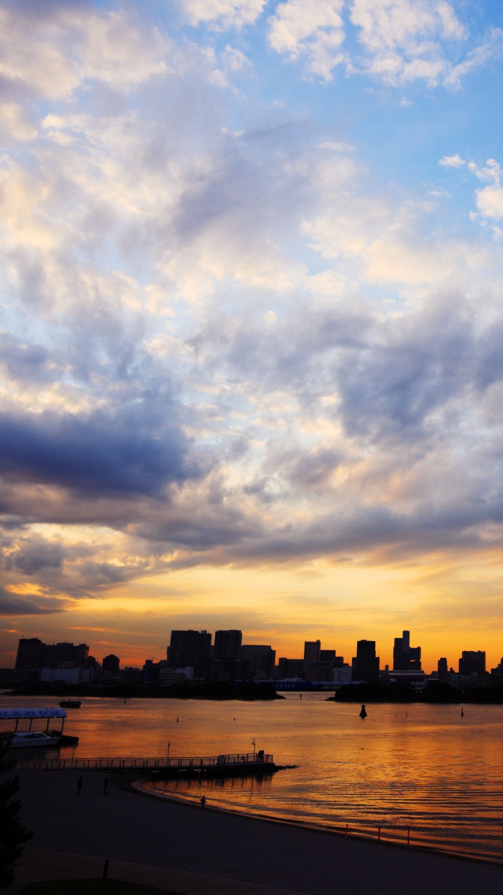 Silhouette of City Buildings Near Body of Water During Sunset. Wallpaper in 720x1280 Resolution