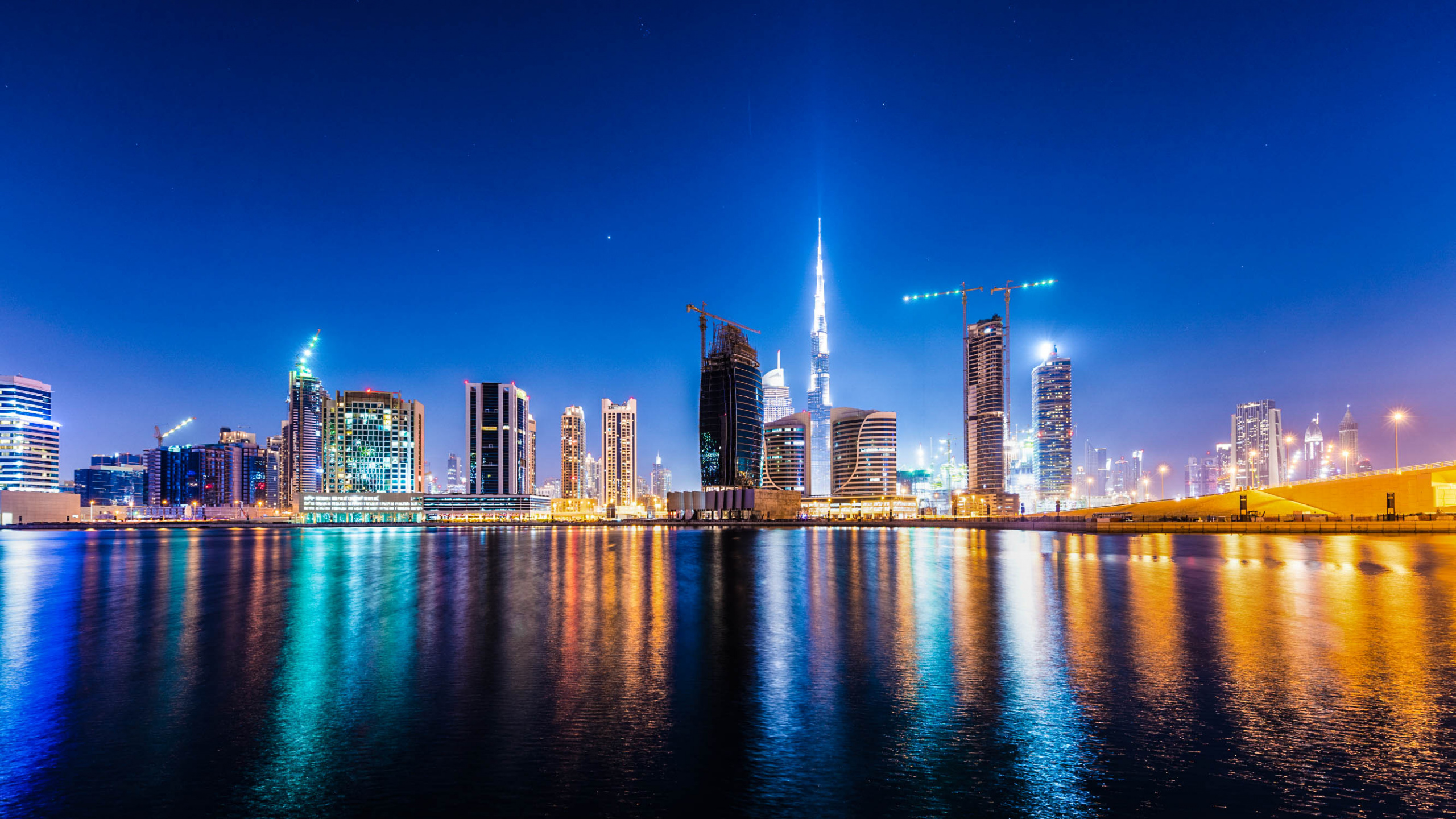 City Skyline Across Body of Water During Night Time. Wallpaper in 2560x1440 Resolution