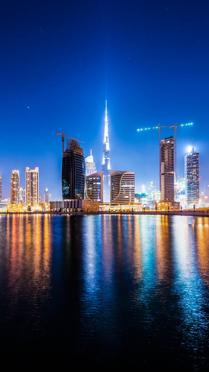 City Skyline Across Body of Water During Night Time. Wallpaper in 720x1280 Resolution