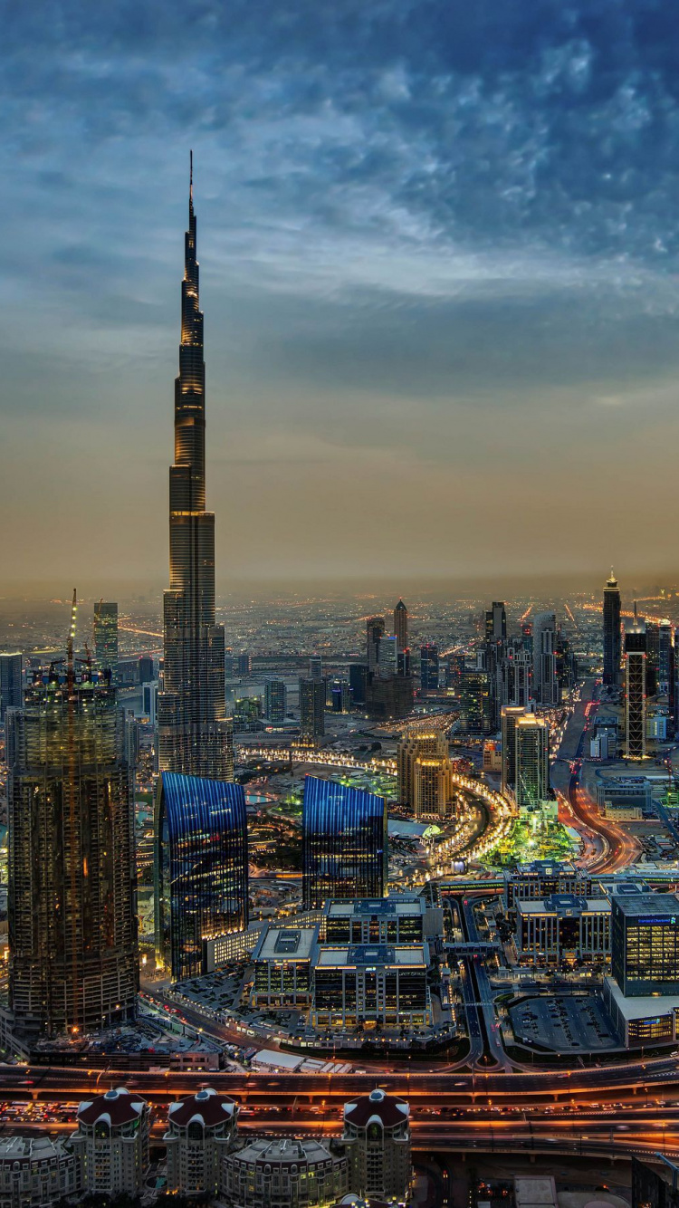 Skyline Der Stadt Unter Blauem Himmel Während Der Nacht. Wallpaper in 750x1334 Resolution