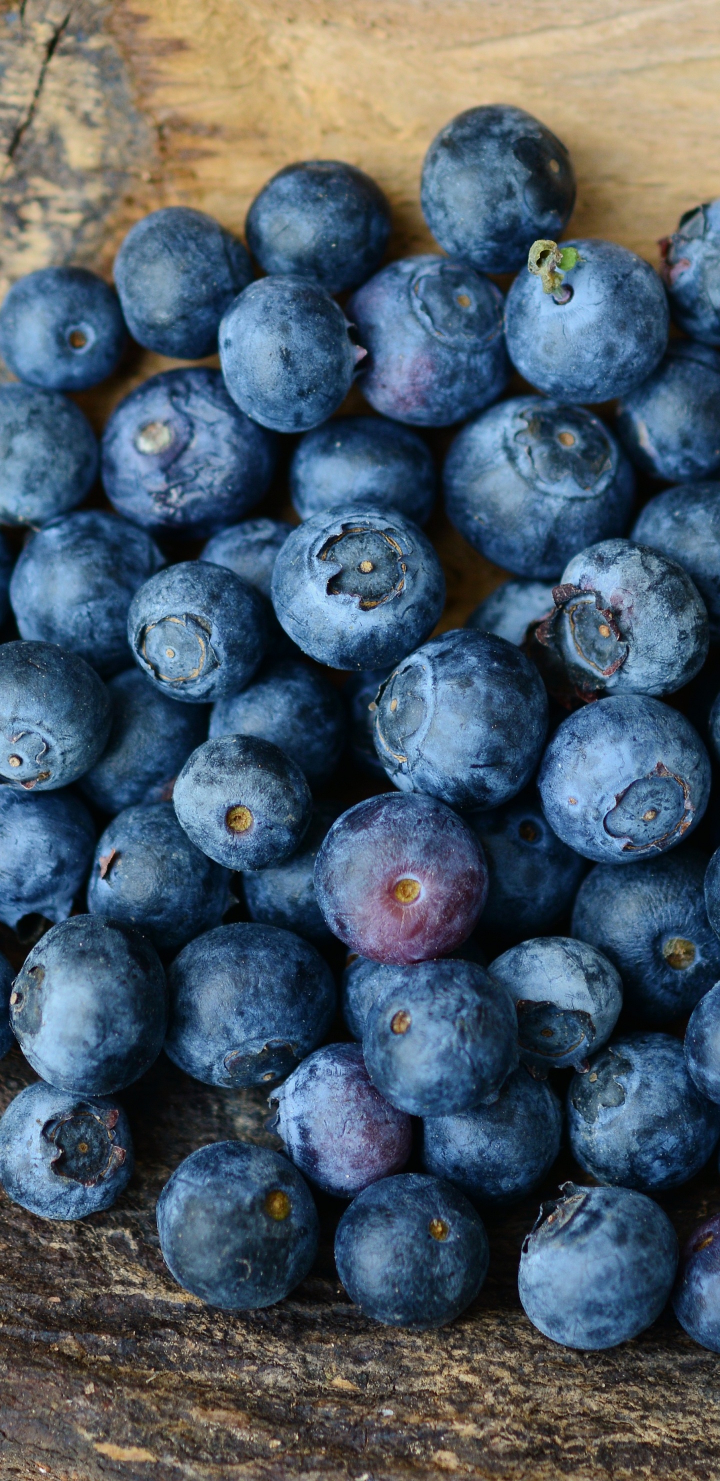 Blaue Beeren Auf Brauner Holzoberfläche. Wallpaper in 1440x2960 Resolution