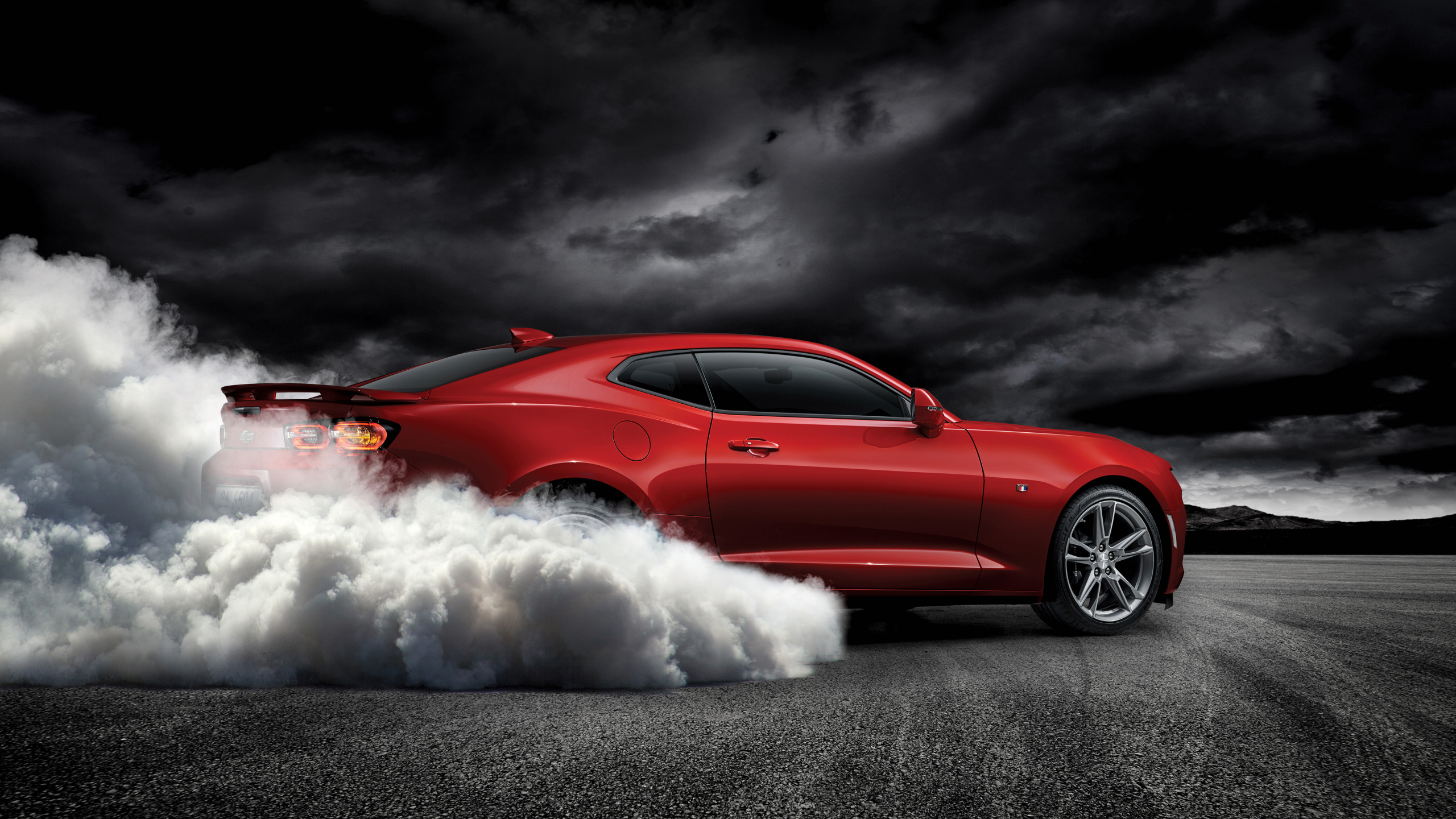 Chevrolet Camaro Rouge Sur Route Asphaltée Grise. Wallpaper in 2560x1440 Resolution