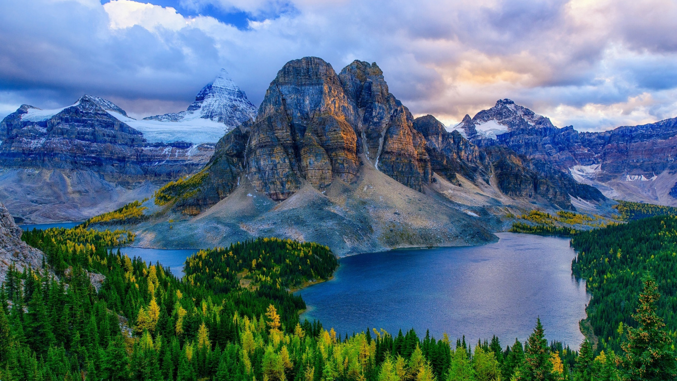 Árboles Verdes Cerca de Cuerpo de Agua y Montaña Bajo Nubes Blancas y Cielo Azul Durante el Día. Wallpaper in 1366x768 Resolution