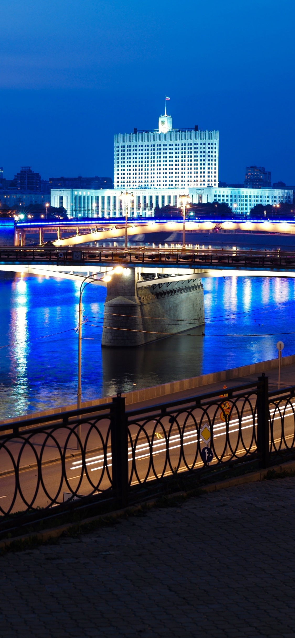 Brücke Über Den Fluss Während Der Nacht. Wallpaper in 1125x2436 Resolution