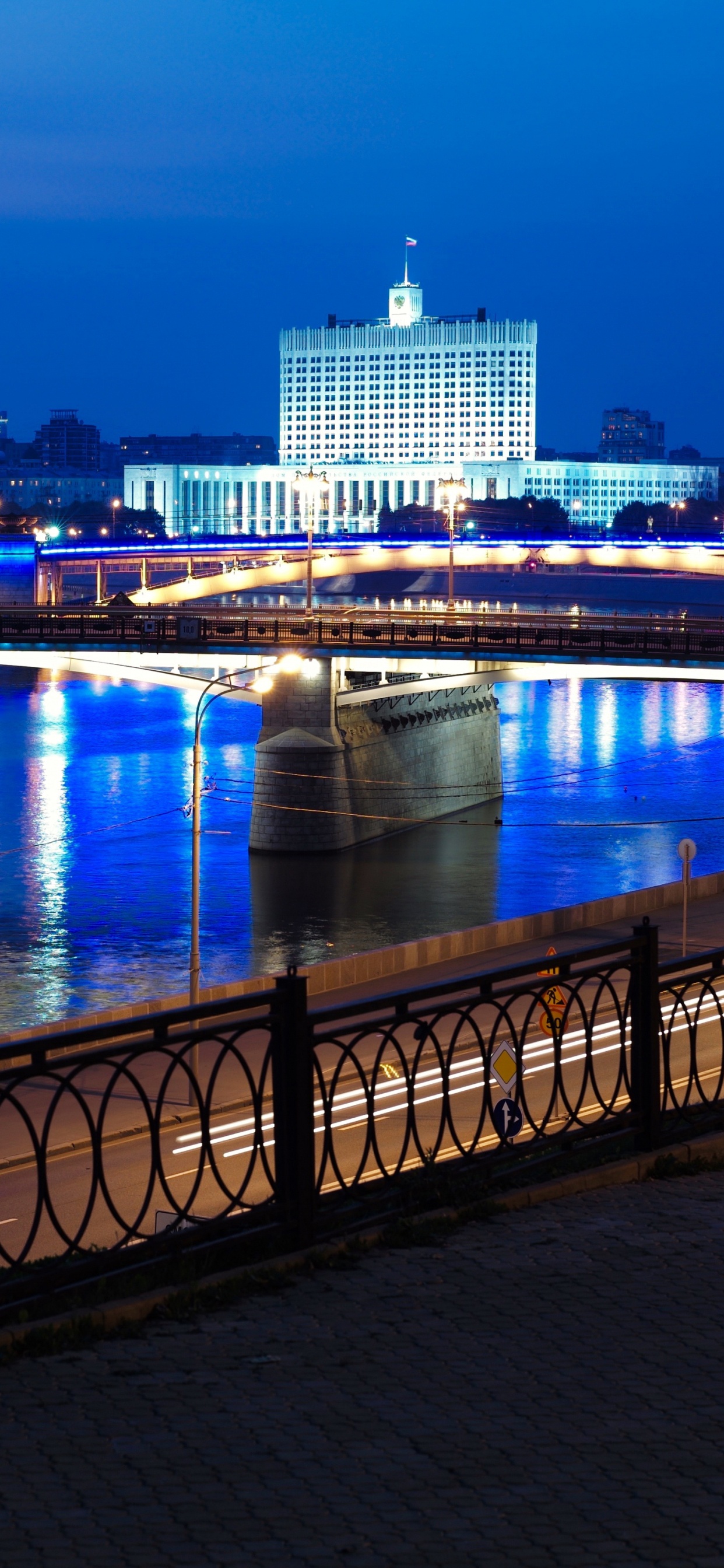 Brücke Über Den Fluss Während Der Nacht. Wallpaper in 1242x2688 Resolution