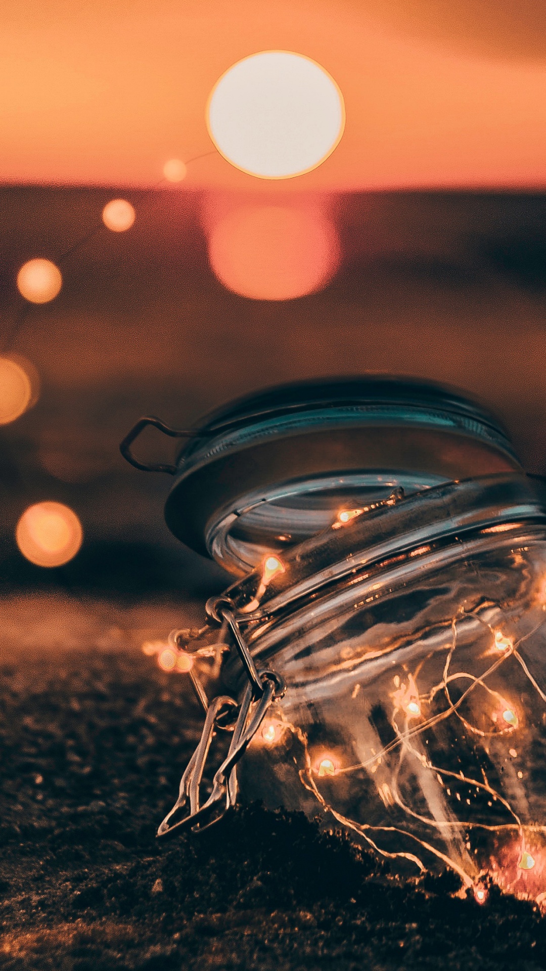 Klarglasbehälter Auf Braunem Sand Bei Sonnenuntergang. Wallpaper in 1080x1920 Resolution
