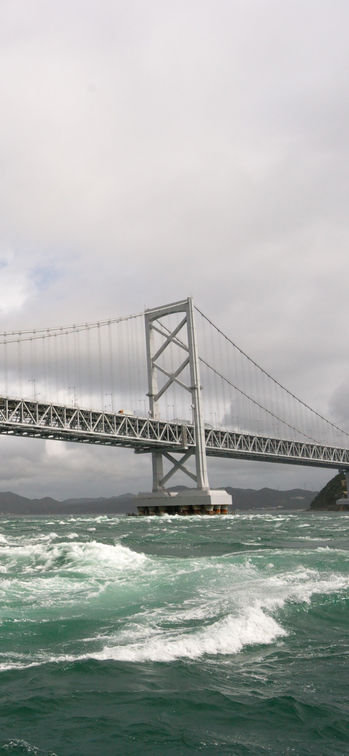 Gray Bridge Over The Sea During Daytime. Wallpaper in 1125x2436 Resolution