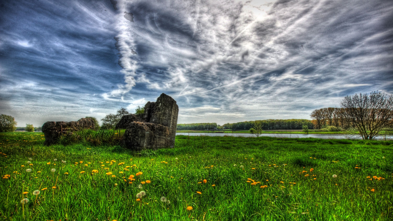 Campo de Hierba Verde Cerca de la Formación Rocosa Marrón Bajo Las Nubes Blancas y el Cielo Azul Durante el Día. Wallpaper in 1366x768 Resolution