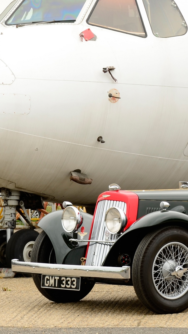 Vintage Black Car Parked Beside White Airplane. Wallpaper in 720x1280 Resolution