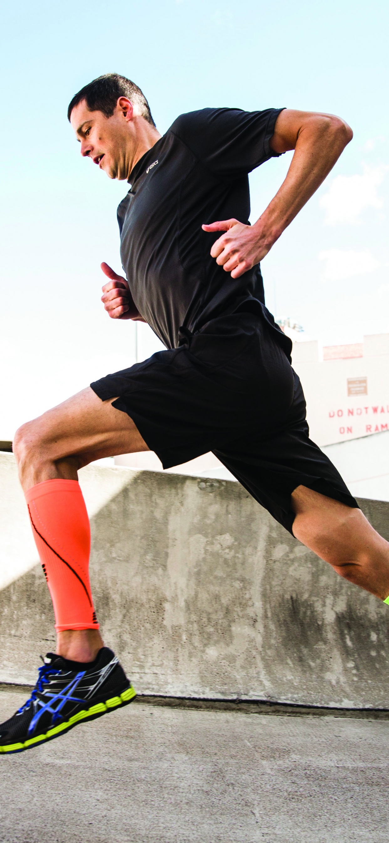 Mann in Schwarzem T-Shirt Und Schwarzen Shorts, Der Tagsüber Auf Grauer Betonstraße Läuft Running. Wallpaper in 1242x2688 Resolution
