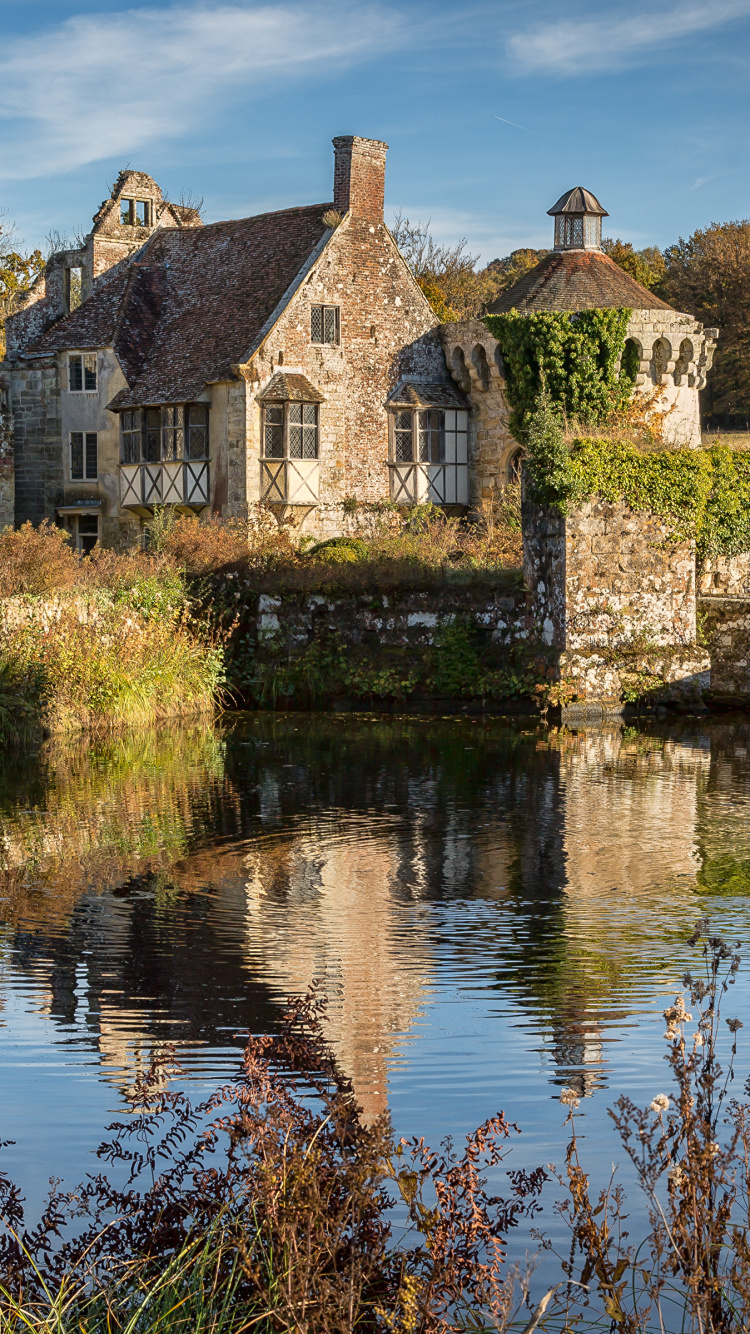 Bâtiment en Briques Brunes à Côté de la Rivière Sous Ciel Bleu Pendant la Journée. Wallpaper in 750x1334 Resolution