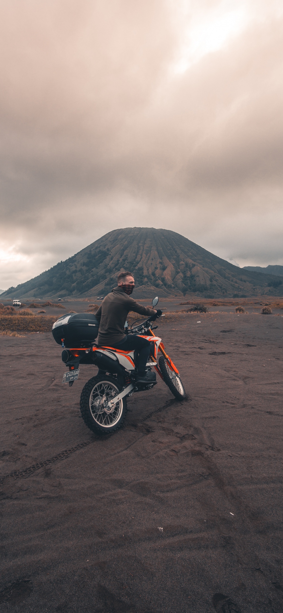 Red and Black Motorcycle on Brown Sand Under Cloudy Sky During Daytime. Wallpaper in 1125x2436 Resolution