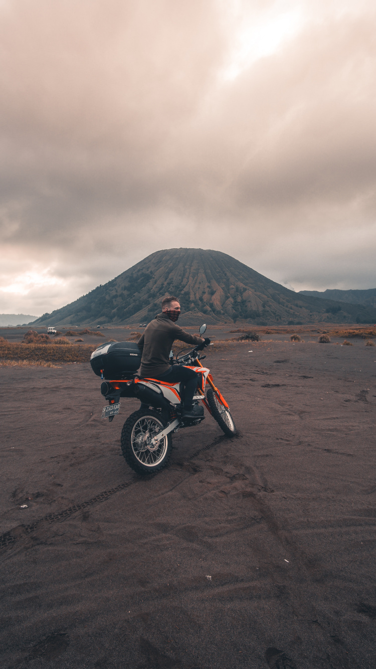 Red and Black Motorcycle on Brown Sand Under Cloudy Sky During Daytime. Wallpaper in 750x1334 Resolution