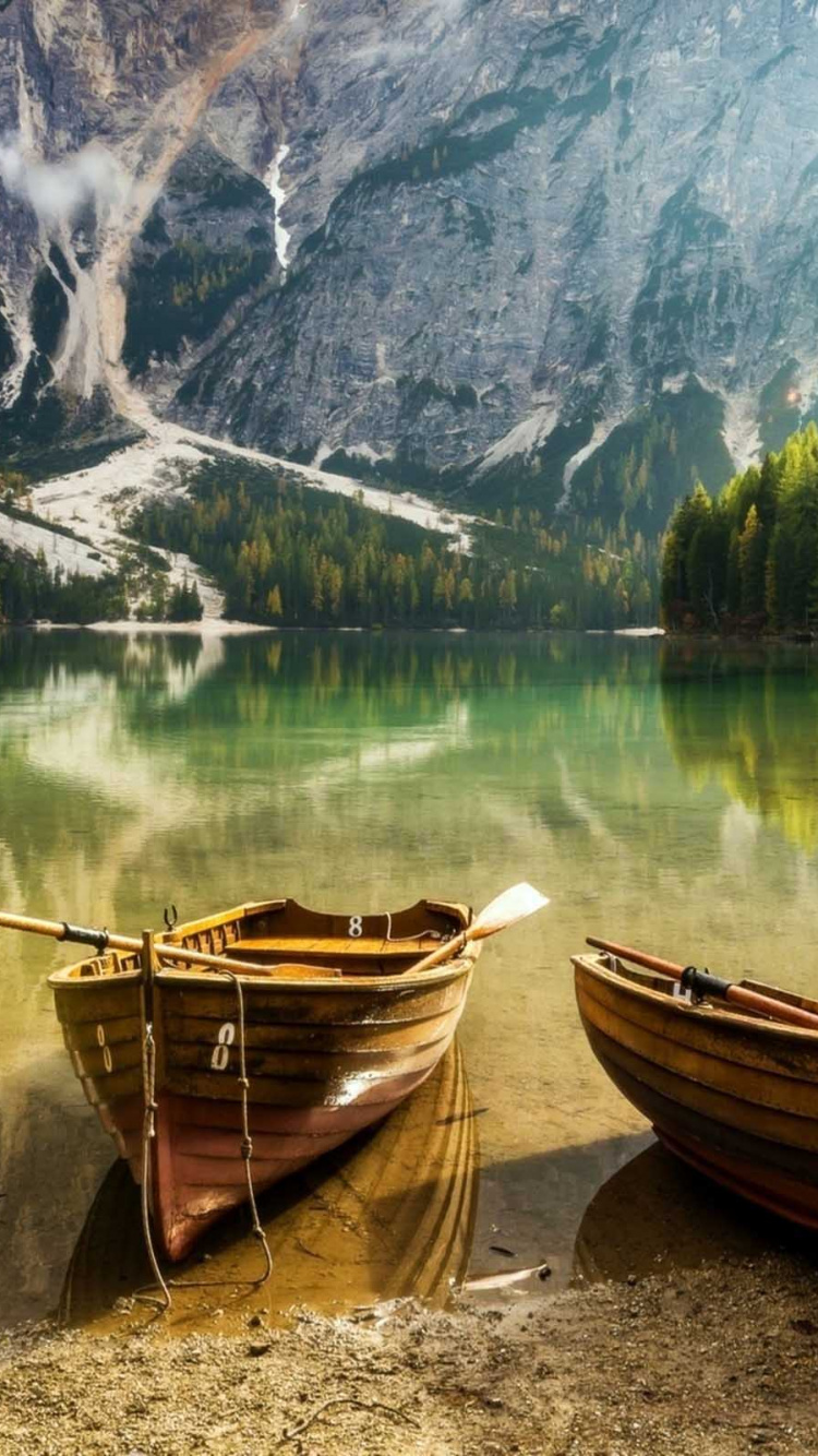 Bateau Brun Sur le Rivage Près Des Arbres Verts et de la Montagne Pendant la Journée. Wallpaper in 750x1334 Resolution