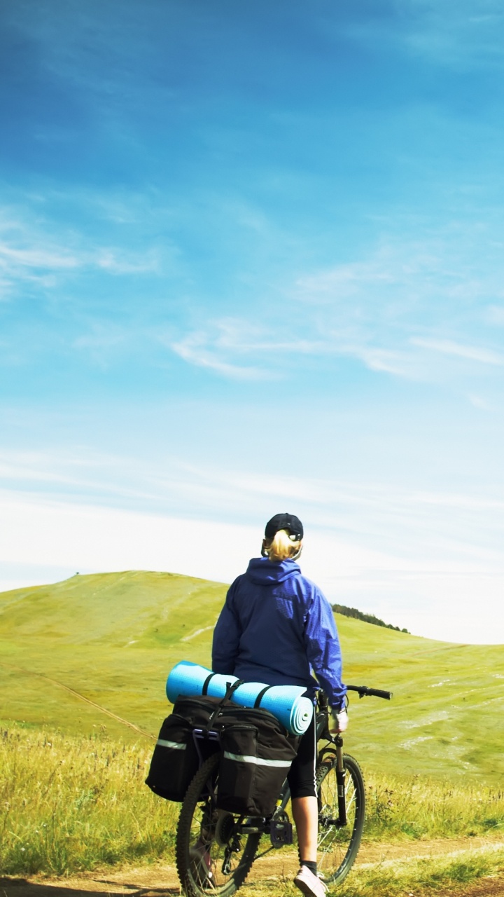 Homme en Veste Bleue et Pantalon Noir Assis Sur un Fauteuil Roulant Noir Sur un Terrain D'herbe Verte Pendant. Wallpaper in 720x1280 Resolution